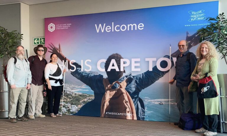A YCG mission team in front of a Welcome to Cape Town sign.