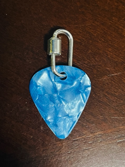 Silver ring holding a shiny, blue guitar pick.