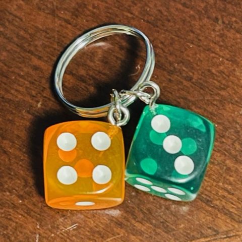 Pair of translucent, orange and green dice hanging from a silver ring.