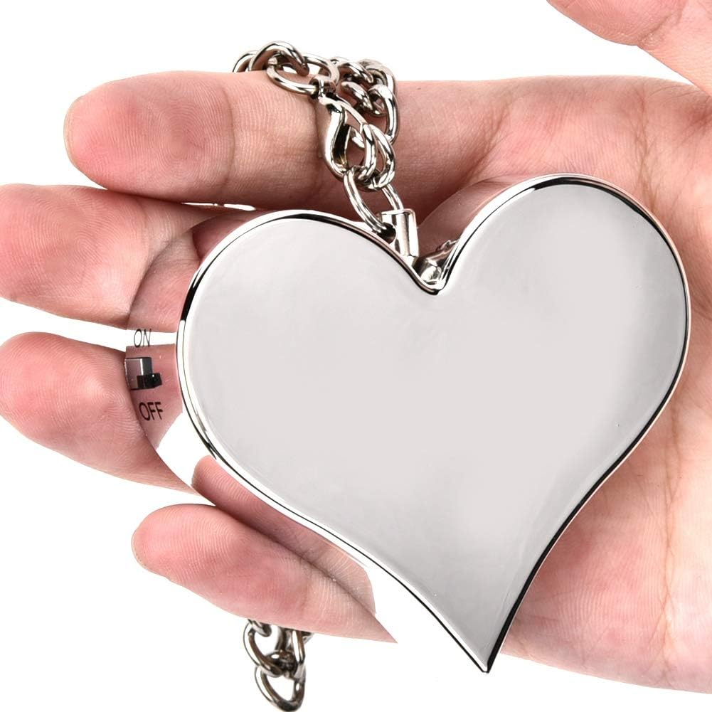 silver heart-shaped charm hanging from a silver chain, sitting in the palm of a hand.