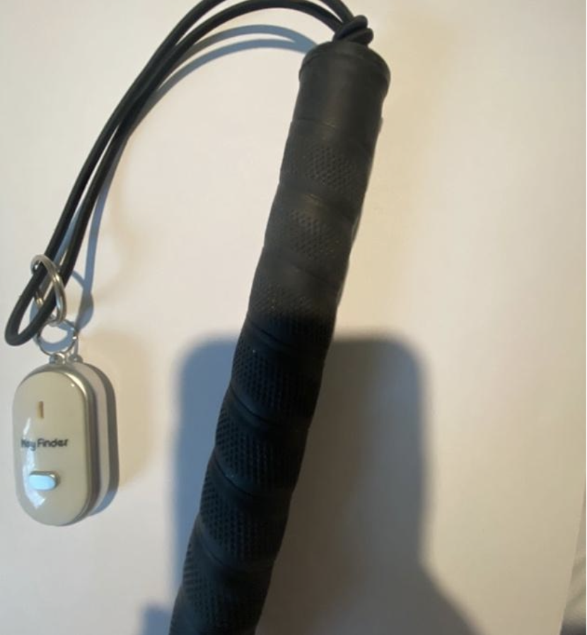 White Whistle Cane finder charm hanging from a cane wrist strap