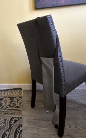 a grey cane pouch hanging from a chair