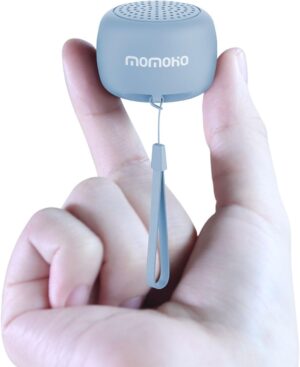 two fingers holding the white tiny bluetooth speaker