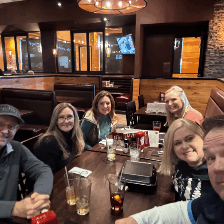 Group of volunteers and board members taking a selfie at a table in a restaurant