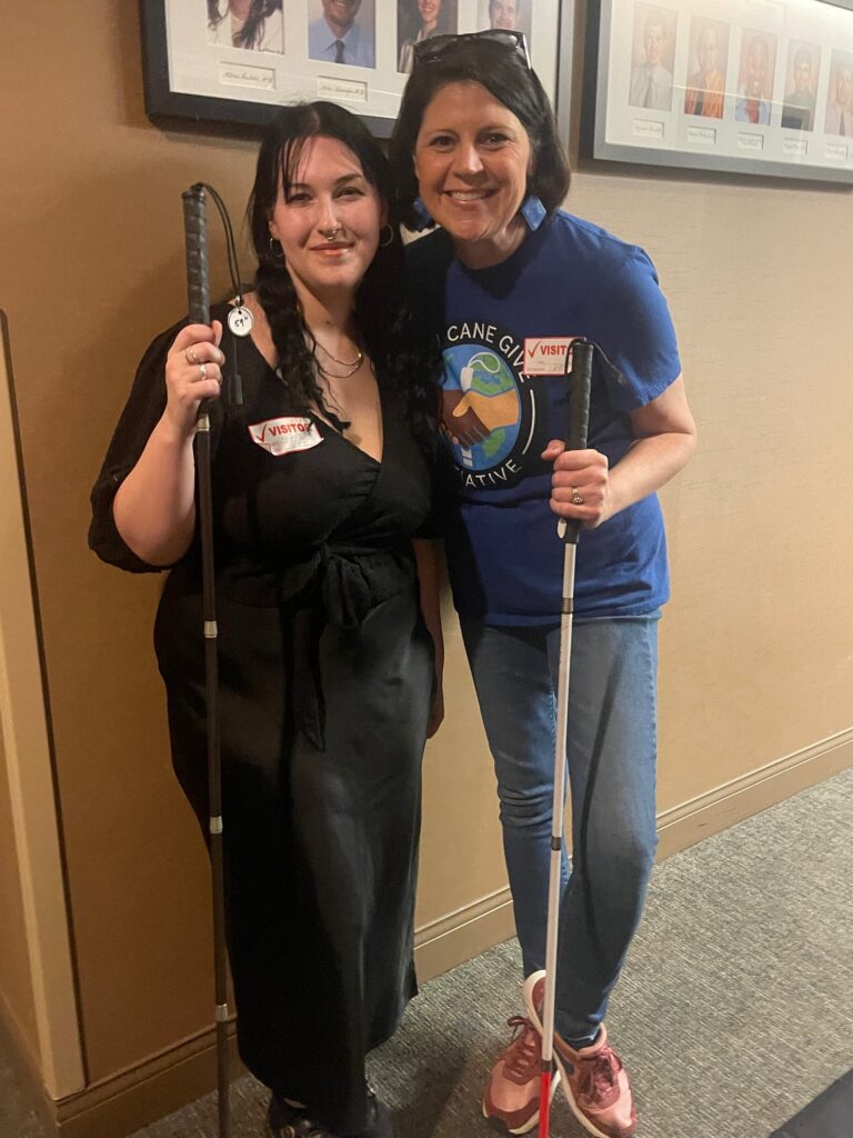 Wendy standing and smiling with a volunteer in a hallway