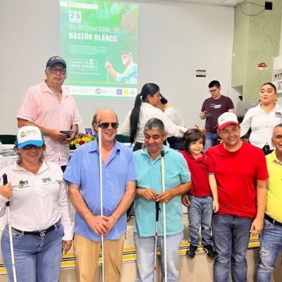 a group of people smiling with their canes at a cane distribution event