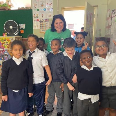 Wendy Boehm smiles with a group of blind students